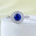 Detailed close-up of a stunning sterling silver halo ring featuring a deep blue round center stone. - Size 5 / R967 Sapphire Blue
