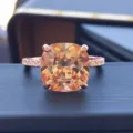 Close-up of sparkling cushion cut orange gemstone ring with pavé band in rose gold. - Size 5 / Rose Gold Champagne Rhinestone