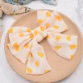 Detail view of a sweet chiffon big bow hair clip with cute yellow heart prints, hair accessory. - Premium Yellow Heart