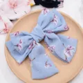Detailed close-up of a blue floral chiffon big bow hair clip, sweet floral spring hair accessory. - Premium Light Blue Floral