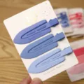 Close-up detail of matte blue duckbill hair clips with embossed logo on white display card. - 3 Pieces/Pack / Three Clips Leaf - Blue Series