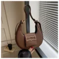 Chic brown crescent shoulder bag for women, stylish underarm purse with metal buckle. - Coffee