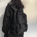 Detailed view of a black utility backpack, large capacity with multiple pockets. - Black