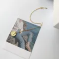 Nahaufnahme Detail der eleganten Goldmünzen-Halskette auf einer ästhetischen Postkarte. - Japanische Kreuzmünzenkette(L117) / Gold
