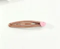 Gros plan détaillé de la charmante pince à cheveux marron avec une décoration de cœur rose. - Brun avec Cœur Rose