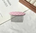 Gros plan du peigne à cheveux en tissu à pois roses avec des dents pour coiffure. - Peigne en Tissu à Pois Rose