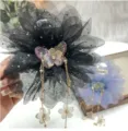 Gros plan détail de la pince à cheveux fleur en filet noir avec papillon et chaînes pendantes. - 11cm / Noir