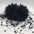 Gros plan sur la pince à cheveux en dentelle noire avec élégants fils de perles en cascade. - A164 Perlé Double Fleur Noir