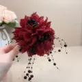 Vue détaillée de la pince à cheveux fleur en tissu rouge foncé avec franges de perles. - A165 Perlé Fleur Unique Rouge