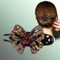 Gros plan de la pince à cheveux papillon en strass montrant des cristaux exquis. - Ambre Rouge Foncé