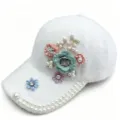 Nahaufnahme der weißen Plüsch-Baseballcap mit Blumenapplikationen, Perlen und Strass. - Erwachsene, Hutumfang 58cm Verstellbar / Weiß