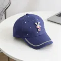Gedetailleerd uitzicht op de blauwe kinderpet met strass konijnenhanger en fonkelende randafwerking. - Kinderen verstelbare hoofdomtrek 54cm / Blauw