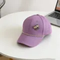 Close-up detail of a purple kids baseball cap featuring a sparkling rhinestone bow and chain. - 54cm Adjustable / Purple