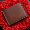 Primo piano di un portafoglio corto da uomo in pelle marrone su carta decorativa rossa. - Caffè Chiaro