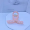 Detail view of a sweet pink acrylic hair claw clip, elegant medium size hair accessory. - Jelly Pink