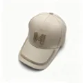Close-up detail of beige baseball cap with rhinestone M logo and sparkling brim trim. - Khaki / Adult, Hat Circumference 58cm Adjustable