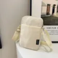 Einfarbig Mini Schulter Umhängetasche für Damen, lässige Nylon Handytasche mit verstellbarem Gurt. - Gebrochenes Weiß