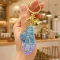 Iridescent shell keychain with gold metal ring and cute bell pendant for bags and keys. - Iridescent Conch Keychain (Blue)