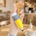 Close-up detail of the creative pencil shape decompression keychain pendant toy in hand. - Yellow