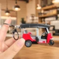 Dettaglio ravvicinato di un portachiavi creativo in miniatura tuk-tuk a tre ruote con anello. - Triciclo Turistico (Rosso)