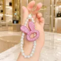 Detail shot of a Korean-style rhinestone bunny keychain with a chic pearl chain for bags. - Hollow Rabbit Head Pearl Chain (Pink)
