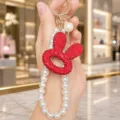 Korean style rhinestone rabbit head keychain with elegant pearl chain luxury bag pendant charm. - Hollow Rabbit Head Pearl Chain (Red)