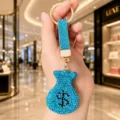 Gros plan détaillé d'un magnifique porte-clés sac d'argent en strass bleus brillants. - Bleu lac