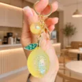 Close-up detail of cute lemon keychain, jelly acrylic fruit bag charm with gold metal ring. - Acrylic Jelly Lemon (Yellow)