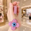 Pink rhinestone clover keychain detail view, sparkly evil eye pendant for stylish bag charm accessory. - Pink