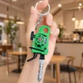 Close-up of creative chainsaw keychain pendant, featuring miniature tool design and sturdy metal ring. - Drill Style / Green