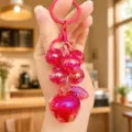 Detailed view of pink glitter bubble grape and apple keychain, stylish cute bag charm pendant. - Red