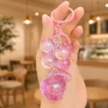 Close-up of the cute pink crystal bubble grape and apple keychain charm, showing details. - Pink