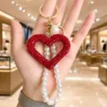 Red rhinestone hollow heart keychain with elegant pearl strap stylish bag charm accessory. - Red