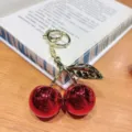 Cute glossy red cherry keychain and stylish bag charm with golden leaf for women girls. - Bright Red Metallic Cherry