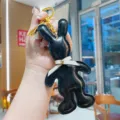 Detailed view of black PU leather rabbit keychain with cute white bow tie and gold metal ring. - Black