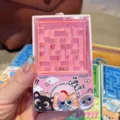 Close-up detail of a cute pink mini maze keychain toy with cat graphics and steel rolling ball. - Pink Cat Floating Maze