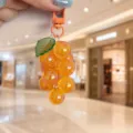 Clear acrylic grape cluster keychain, cute fruit bag charm and aesthetic phone strap detail. - Orange Grape With Green Leaves