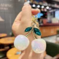 Detailed shot of dazzling crystal cherry bag charm keychain with sparkling iridescent resin fruit. - White Iridescent Green Leaf Cherry