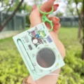 Detailed view of creative electronic drum keychain toy with cute frog design, portable music gadget. - Electronic Drum Set / Green Frog