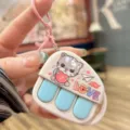 Cute cat music keychain toy close-up detail, showing interactive buttons and love pattern. - Purple Cute Bear