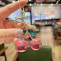 Cute pink cherry keychain, elegant gold metal bag pendant, sparkling crystal leaf charm accessory. - Pink Metallic Green Leaf Cherry