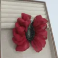 Gros plan d'une pince à cheveux rouge en organza vif avec des fils brillants, présentée proprement. - Rouge