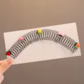 Close-up detail of the black metal hair clip decorated with cute colorful fruit resin charms. - Fruit Hair Side Comb