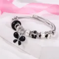 Dettaglio ravvicinato del bracciale con ciondolo a farfalla nera e cristalli scintillanti. - Nero