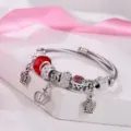 Bracciale rigido in filo argentato con perle di cristallo rosso e graziosi pendenti. - Rosso