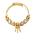 Primo piano dettaglio del bracciale con ciondoli in acciaio inossidabile dorato. - Bianco