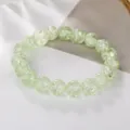 Primo piano dettaglio del braccialetto di perle di cristallo verde chiaro, texture fine. - Verde