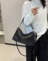 Detailed view of the stylish black genuine leather shoulder bag, minimalist daily accessory. - Black