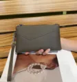 Grey leather wristlet clutch bag for women, featuring a secure zipper and handy strap. - Khaki