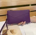 Λεπτομέρεια μωβ δερμάτινης τσάντας clutch, φερμουάρ με λουράκι καρπού, κομψό αξεσουάρ. - Μωβ